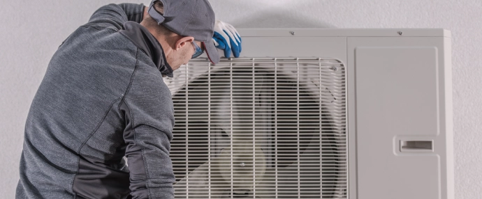 Techniker installiert Außengerät einer Wärmepumpe an einer Hauswand in Pforzheim.